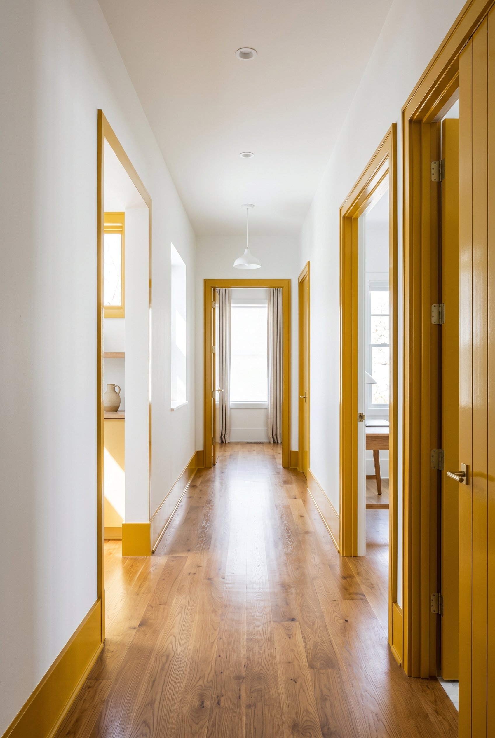 Photorealistic interior photo. A bright hallway with stark white walls and high-gloss mustard yellow baseboards and door framing. Crisp clean lines, hardwood floors. Bright natural lighting, straight-