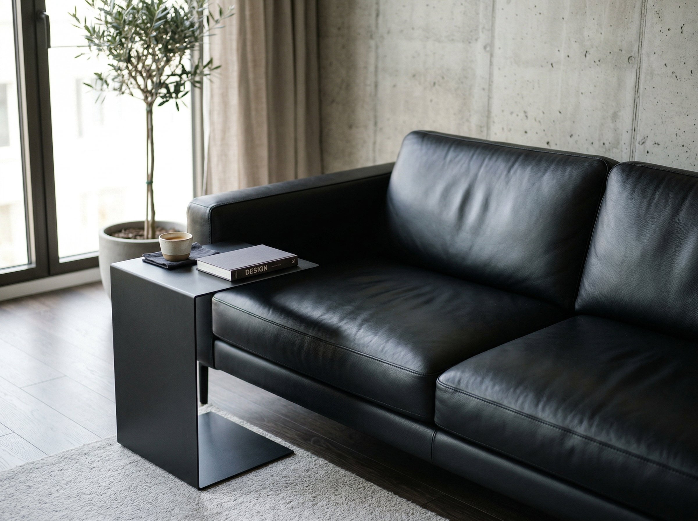 Photorealistic interior photo. Sleek black leather sofa, pristine condition, next to a minimalist matte black side table, bright daylight highlighting the leather sheen, tight focus angle. Editorial p